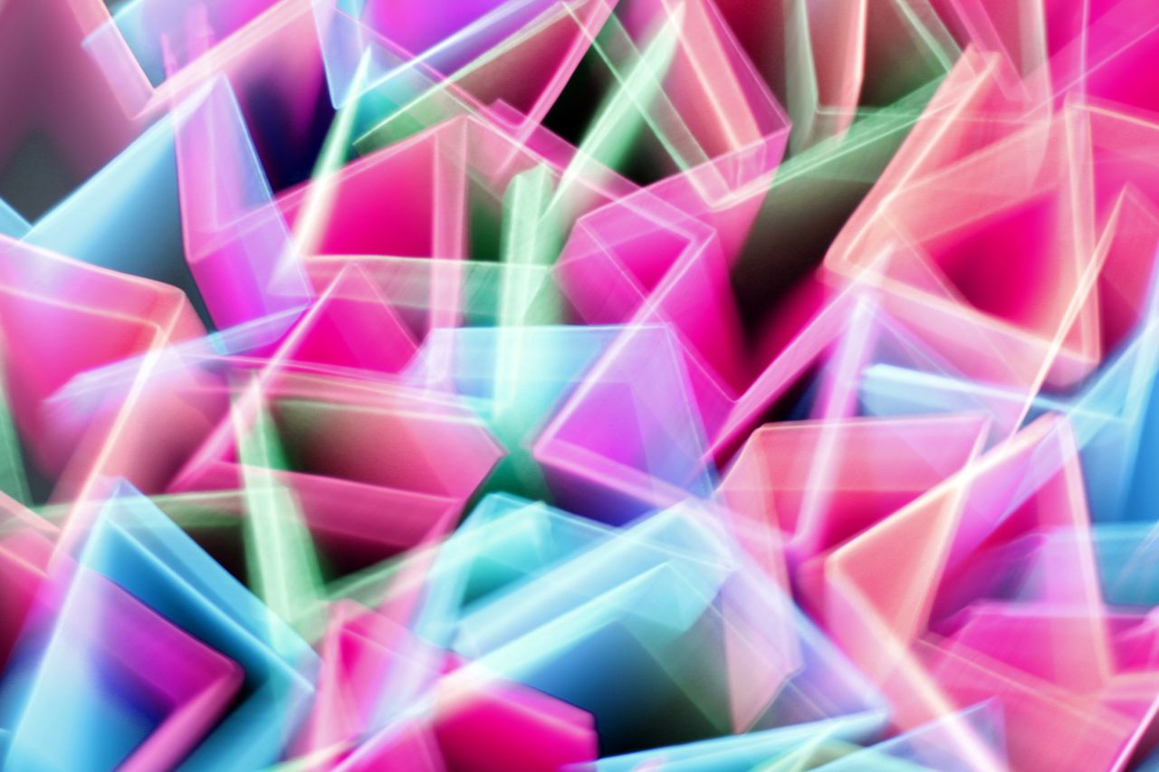 Abstract pattern of overlapping translucent shapes in pink, teal and white